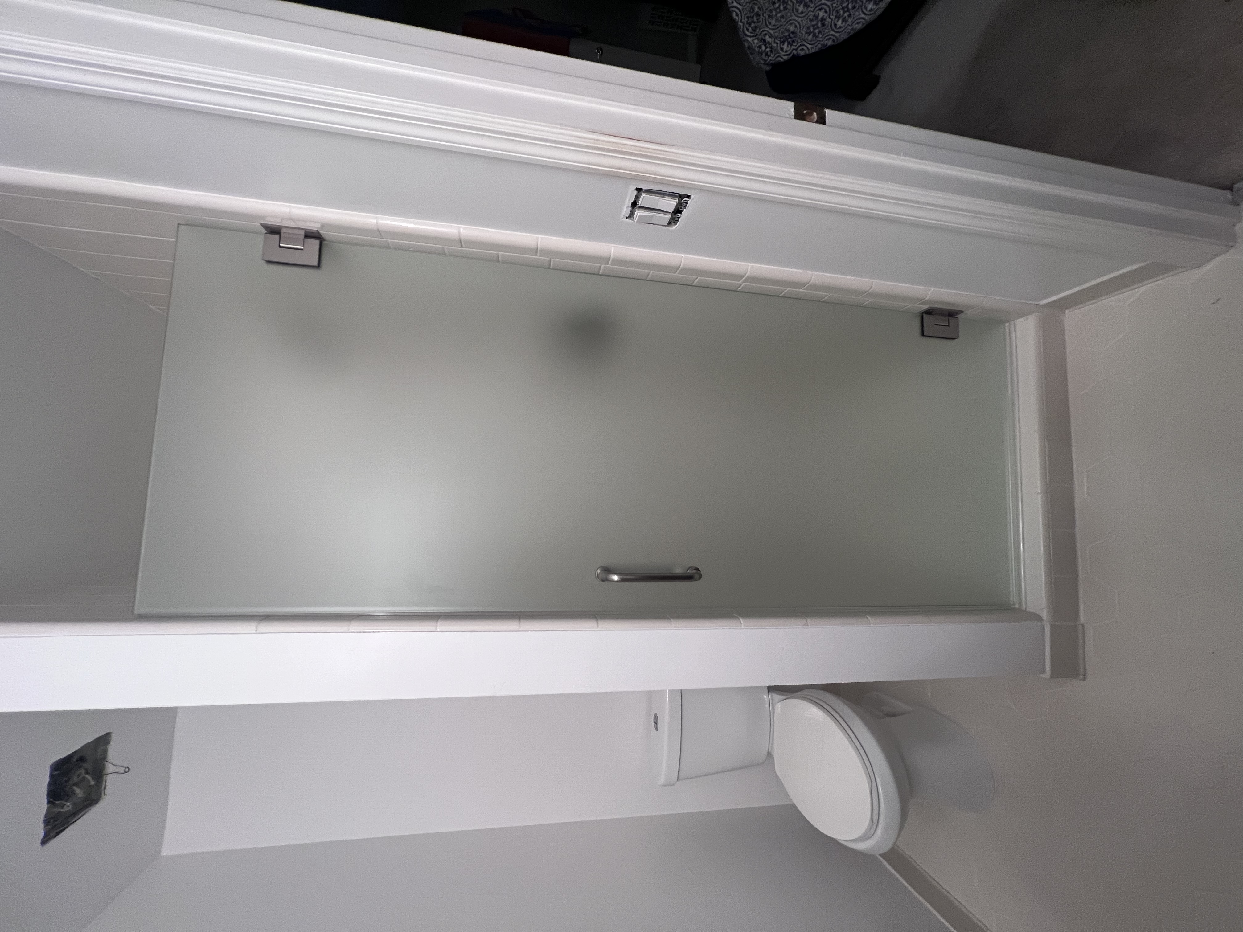 A frosted glass single door with a chrome finish.