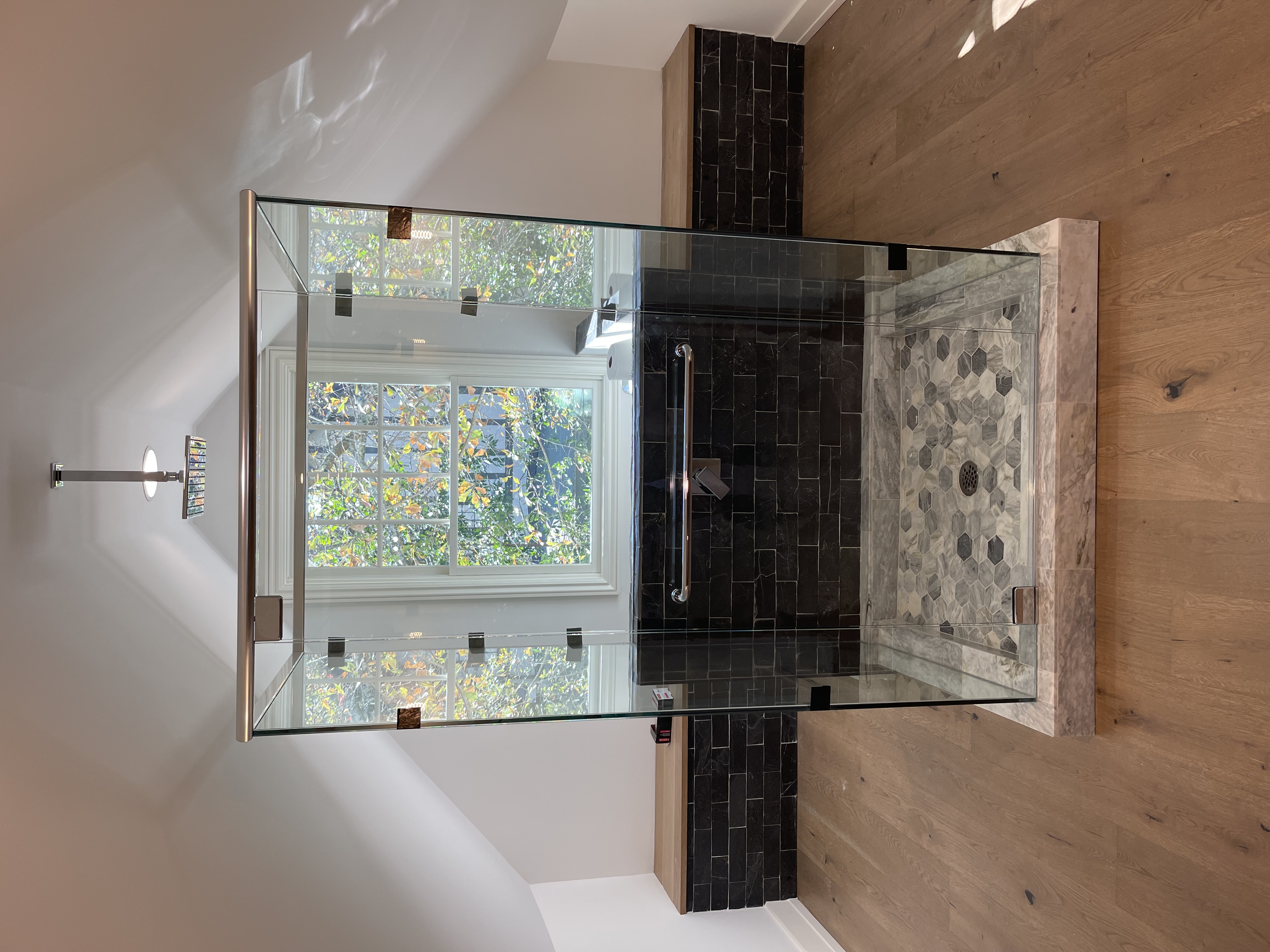 This shower is a three sided cube with a fourth side on a half wall where the plumbing is located!